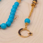 ⁦سبحة من حجر الفيروز مطلية بالذهب ومزينة بشرابة من الزركون⁩ - الصورة ⁦2⁩