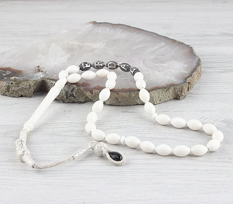 سبحة من عظم الجمل مع شرابة فضية ومكتوب عليها الاسم